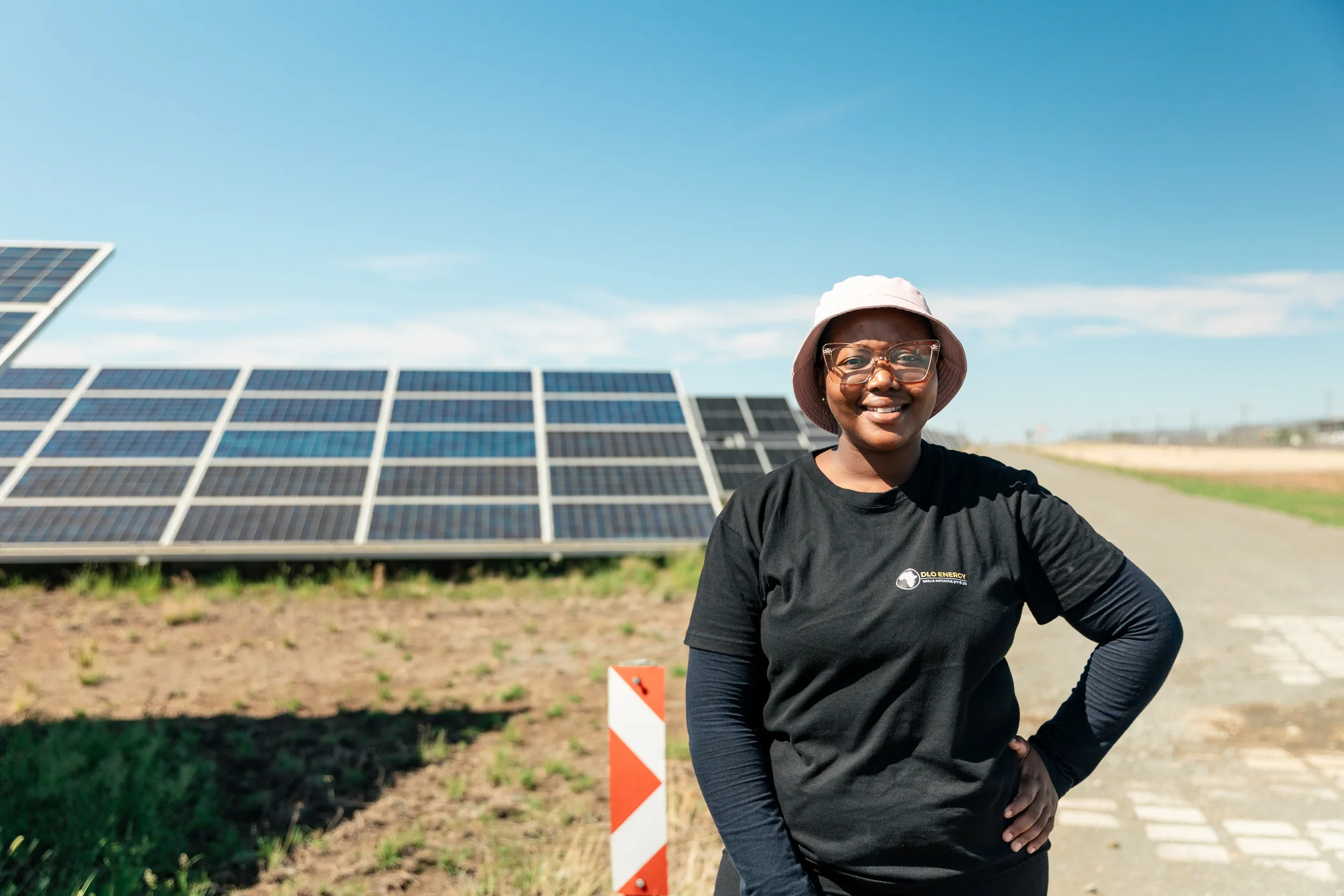 A person standing beside solar panels at an outdoor installation
